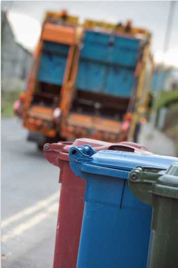 Refuse Lorry with bins at the side of the road